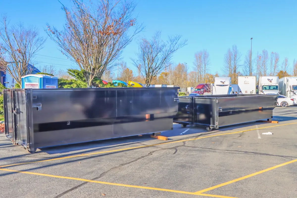 Professional dumpster rental service with roll-off container on residential driveway in Oelwein